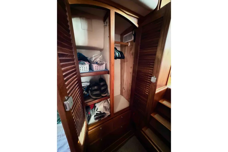 Slide: The Image of Wooden closet interior on 2003 Pacific Seacraft 38T Fast Trawler, featuring shelves and hangers. - 145