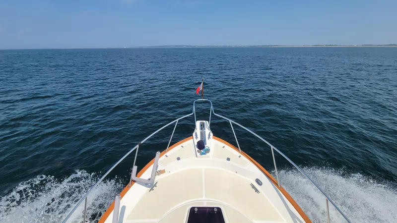 Slide: The Image of A boat cruising on calm waters with a clear view of the horizon. - 6