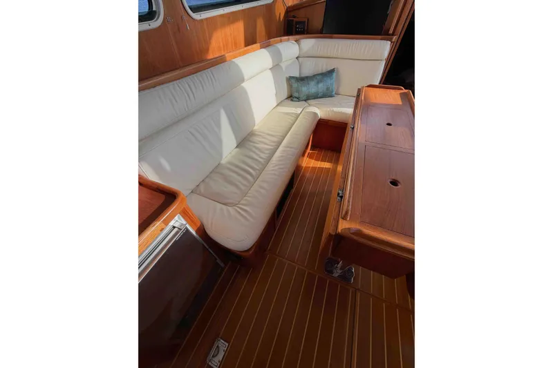 Slide: The Image of Interior of 2003 Pacific Seacraft 38T Fast Trawler with white seating and wooden table. - 133