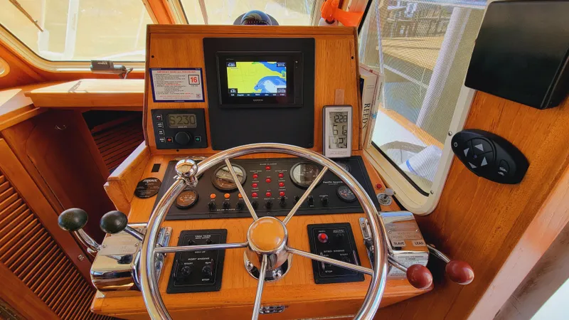 Slide: The Image of The image shows the helm of a 2003 Pacific Seacraft 38T Fast Trawler with wood paneling and navigation system. - 1
