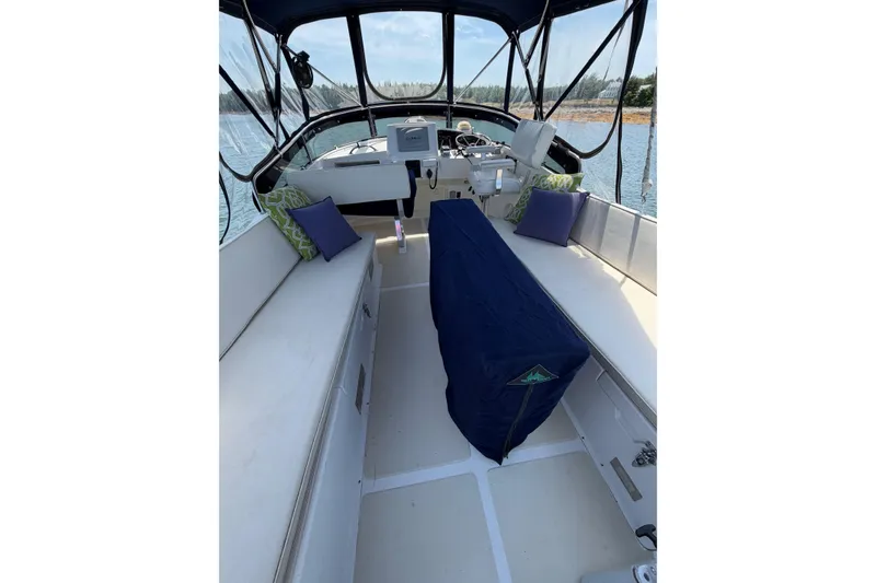 Slide: The Image of 2003 Pacific Seacraft 38T Fast Trawler interior with seating and helm, docked on calm water. - 109