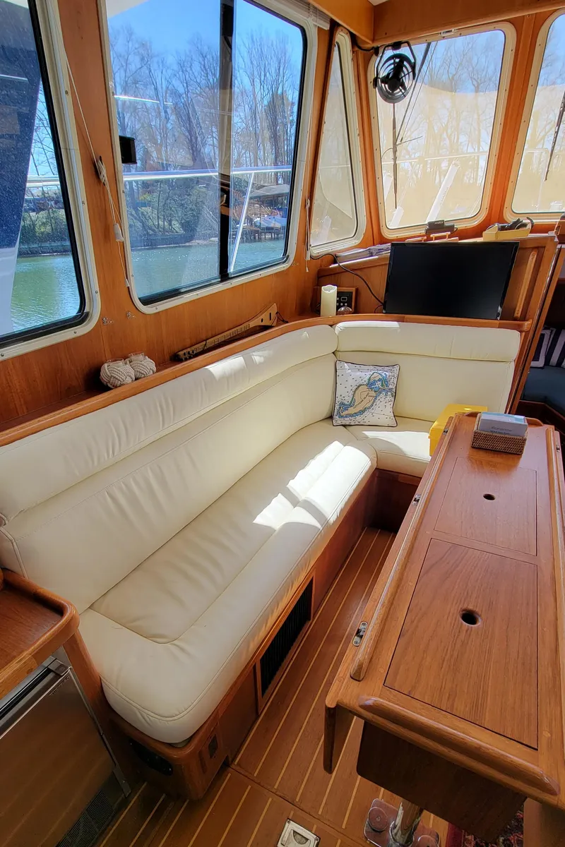 Slide: The Image of Interior of a 2003 Pacific Seacraft 38T Fast Trawler with beige sofa and wooden table. - 17