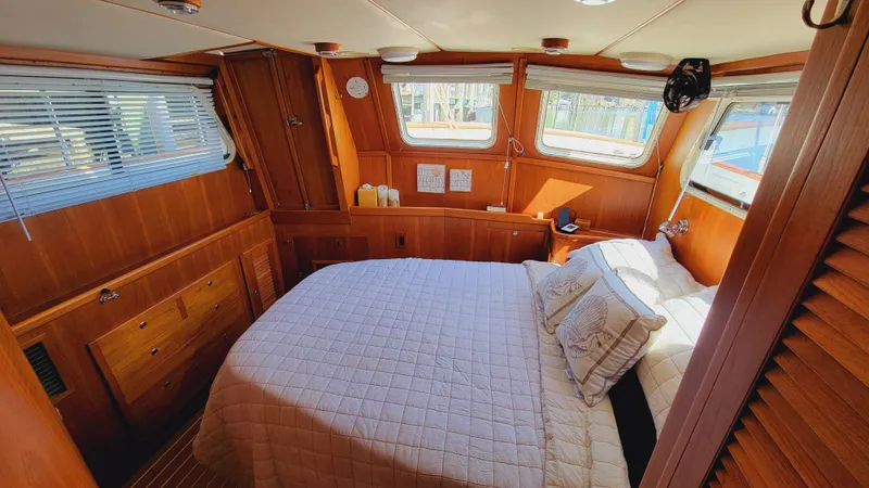Slide: The Image of The image shows a cozy cabin with a double bed, wooden furnishings, and windows. - 28