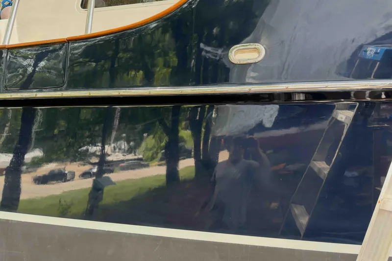 Slide: The Image of 2003 Pacific Seacraft 38T Fast Trawler with reflective blue hull and visible porthole. - 82