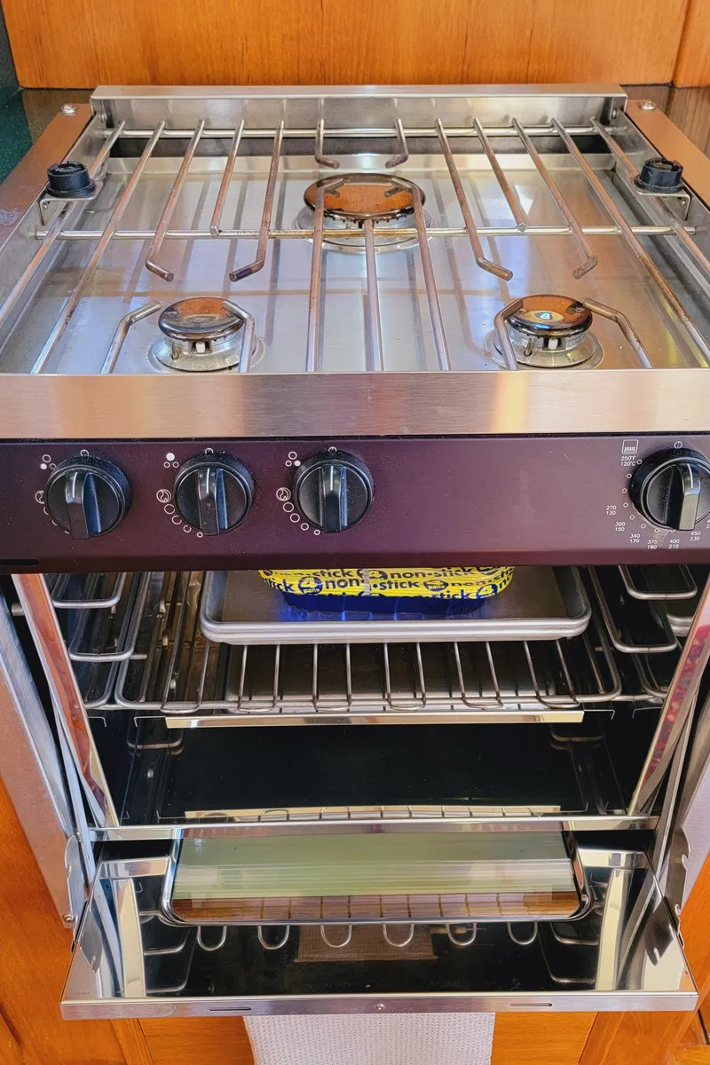 Slide: The Image of A stainless steel stove with four burners and an oven below, set in a wooden kitchen. - 23