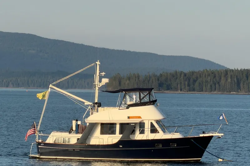 Slide: The Image of Pacific Seacraft 38T Fast Trawler 2003 on serene lake with forested hills. - 89