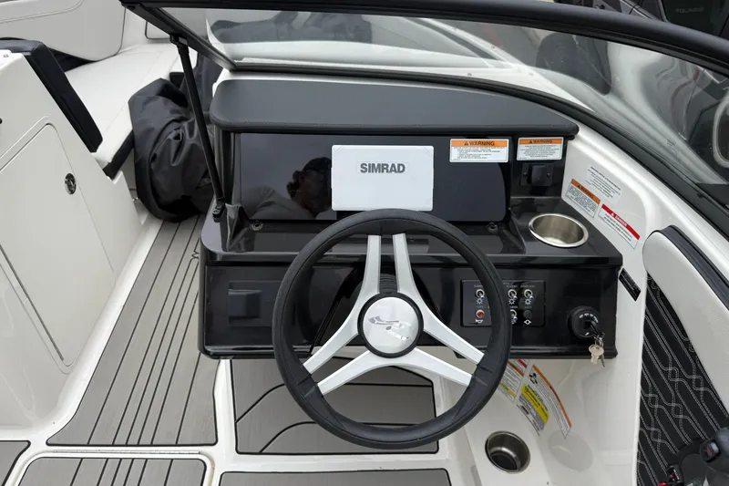 Slide: The Image of 2024 Sea Ray SPX 190 dashboard with steering wheel and Simrad display. - 13