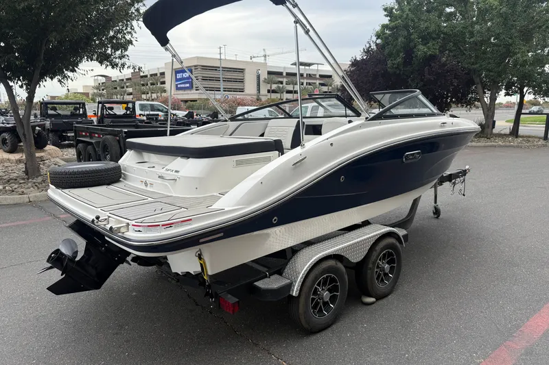 Slide: The Image of 2024 Sea Ray SPX 190 boat on trailer, parked outdoors near trees and vehicles. - 4