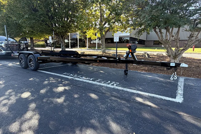 Slide: The Image of Trailer for 2017 MasterCraft X23 boat parked in a lot with trees. - 44