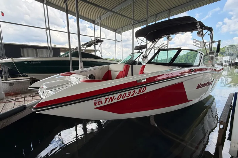 Slide: The Image of 2017 MasterCraft X23 boat in red and white, docked under a covered marina. - 11