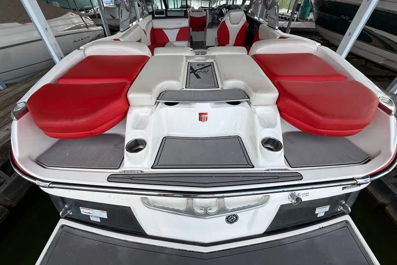 Slide: The Image of 2017 MasterCraft X23 boat with red and white seating, docked in a marina. - 41