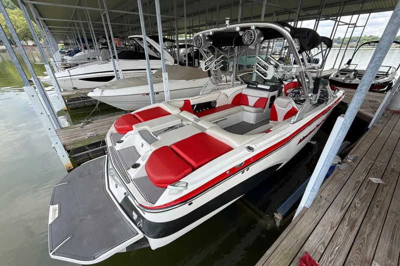 Slide: The Image of 2017 MasterCraft X23 boat with red and white interior docked in a marina. - 12