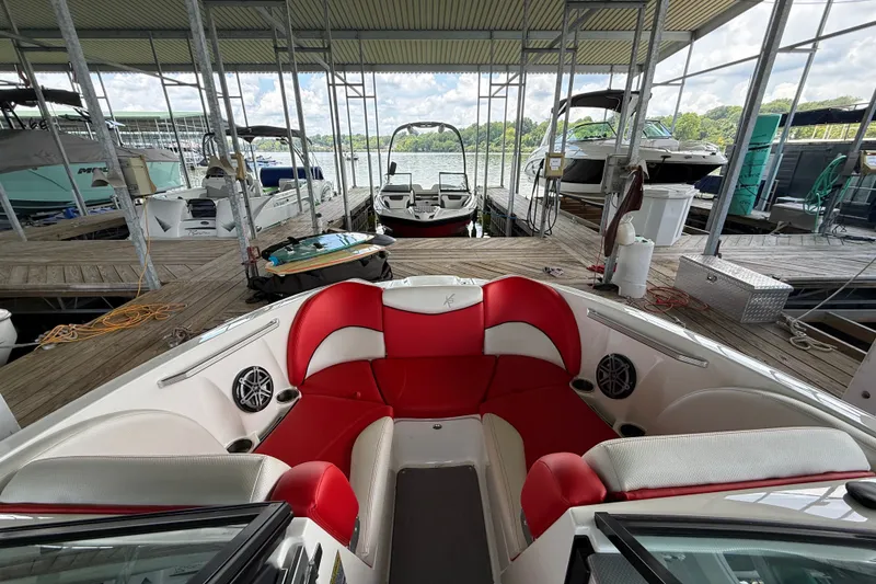 Slide: The Image of 2017 MasterCraft X23 boat with red and white seating docked in a marina. - 27