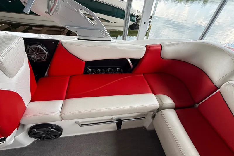 Slide: The Image of 2017 MasterCraft X23 boat interior with red and white seating, cup holders, and speaker. - 35