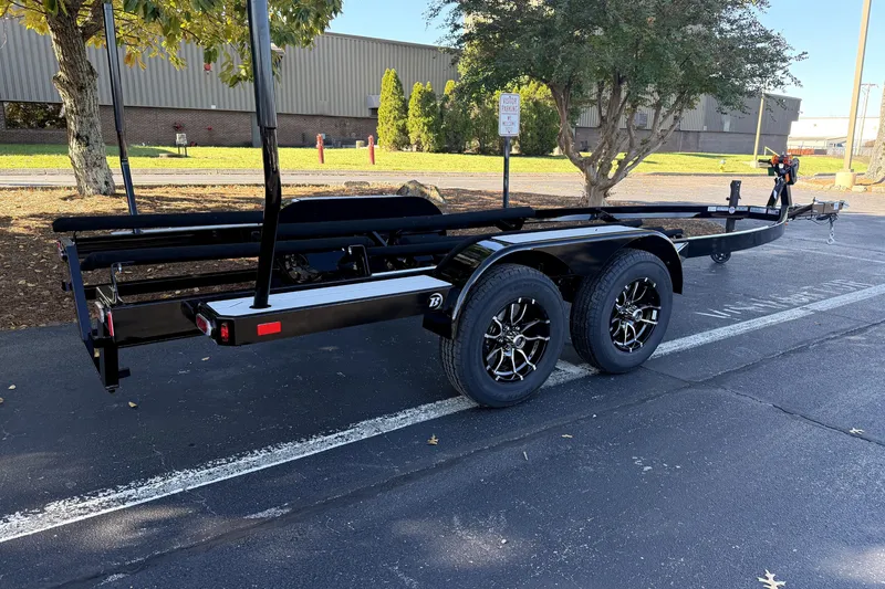 Slide: The Image of Trailer for 2017 MasterCraft X23 boat, parked in a lot with trees nearby. - 43