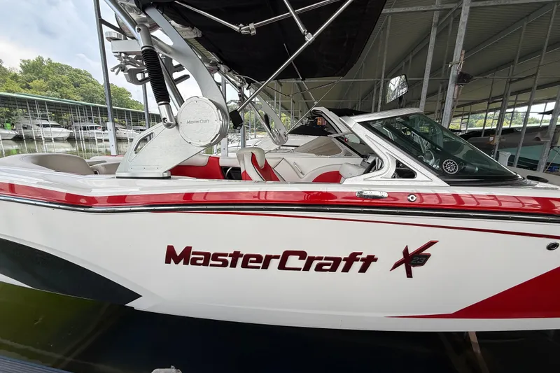 Slide: The Image of 2017 MasterCraft X23 boat docked, featuring sleek design and red accents. - 17