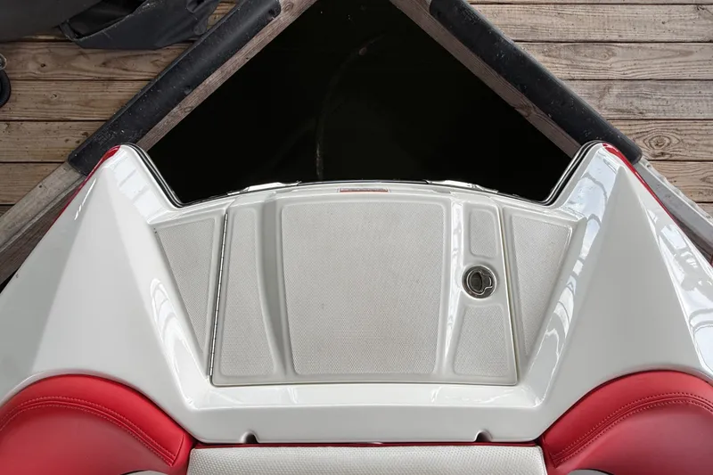 Slide: The Image of 2017 MasterCraft X23 boat stern with red and white seating, docked on wooden pier. - 25