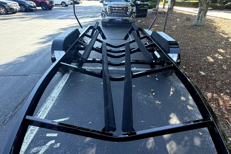 Slide: The Image of Trailer for 2017 MasterCraft X23 boat, parked on asphalt near a GMC vehicle. - 45