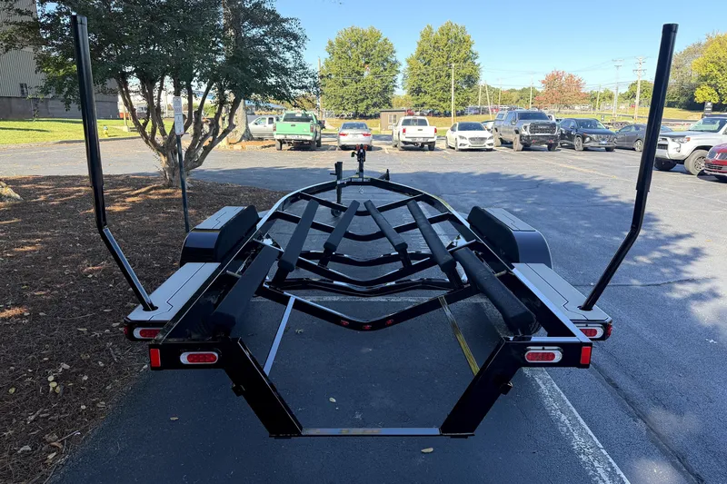 Slide: The Image of 2017 MasterCraft X23 boat trailer in a parking lot, surrounded by trees and vehicles. - 46