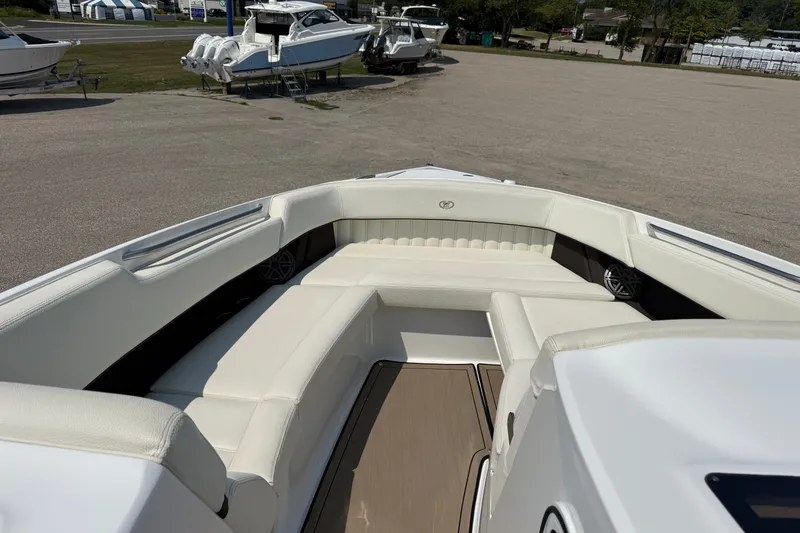 Slide: The Image of 2020 Cobalt R35 boat interior with white seating and wood flooring, parked outdoors. - 14