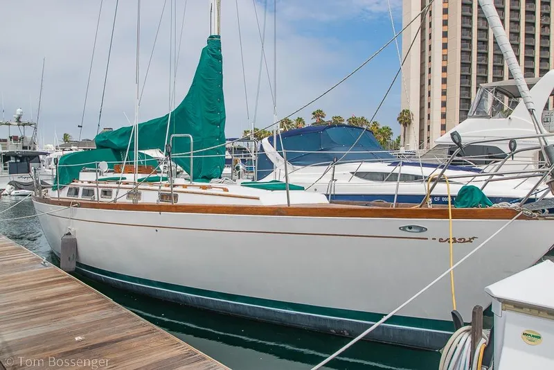 Slide: The Image of 1984 Cheoy Lee Pedrick 41 sailboat docked at a marina with green covers. - 2