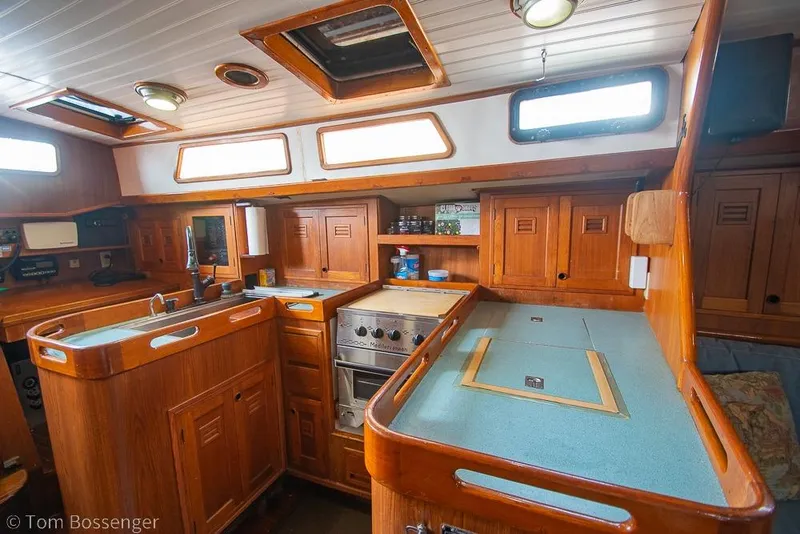 Slide: The Image of Interior of 1984 Cheoy Lee Pedrick 41 yacht, featuring a wooden galley with ample storage. - 9