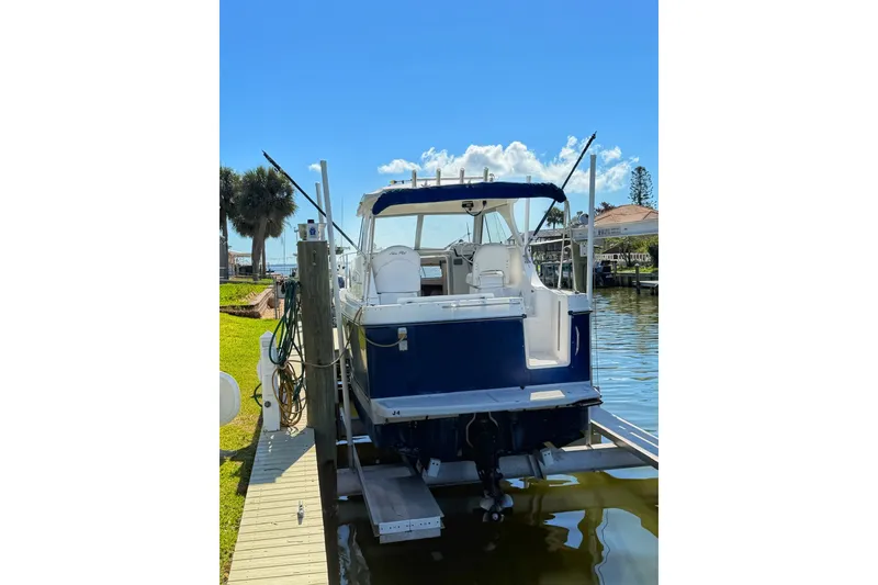 Slide: The Image of 2009 Bayliner Discovery 246 docked on a sunny day, rear view. - 12