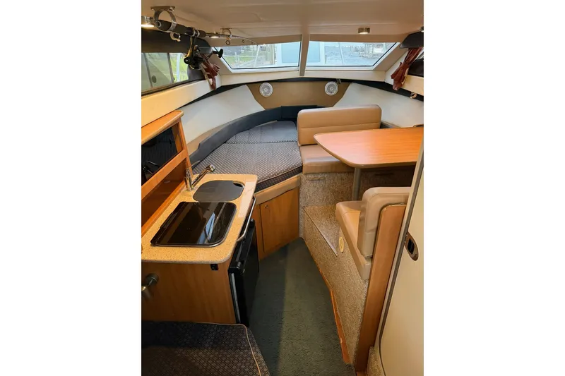 Slide: The Image of Interior of 2009 Bayliner Discovery 246 boat, featuring kitchenette and seating area. - 15