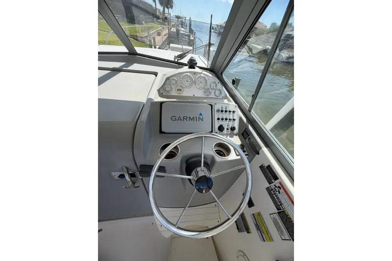 Slide: The Image of 2009 Bayliner Discovery 246 helm with Garmin navigation system and steering wheel. - 9