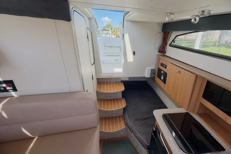 Slide: The Image of Interior of 2009 Bayliner Discovery 246 boat with stairs, kitchenette, and seating area. - 4