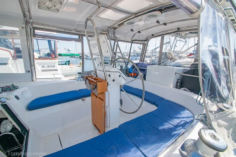 Slide: The Image of 2009 Hunter 50 Center Cockpit with blue seating, steering wheel, and marina view. - 45