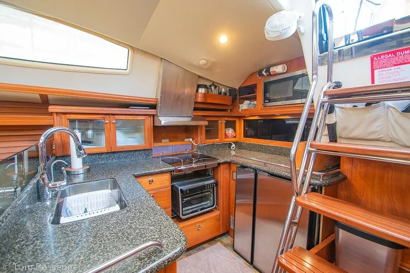 Slide: The Image of Luxurious 2009 Hunter 50 Center Cockpit yacht kitchen with modern appliances and wooden cabinetry. - 11