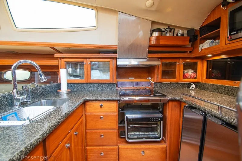 Slide: The Image of Luxurious 2009 Hunter 50 Center Cockpit yacht kitchen with modern appliances and wooden cabinetry. - 12