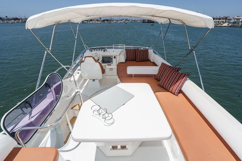 Slide: The Image of Luxurious 2012 Azimut 48 yacht interior with seating, table, and helm, on calm water. - 10