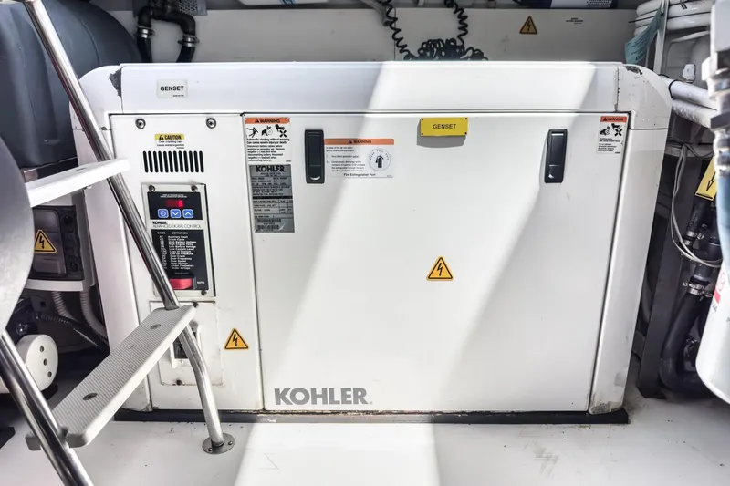 Slide: The Image of Kohler generator in 2012 Azimut 48 yacht engine room, featuring safety warnings and control panel. - 55