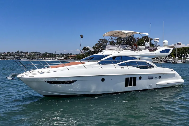 Slide: The Image of 2012 Azimut 48 yacht cruising on a sunny day in a scenic harbor. - 2