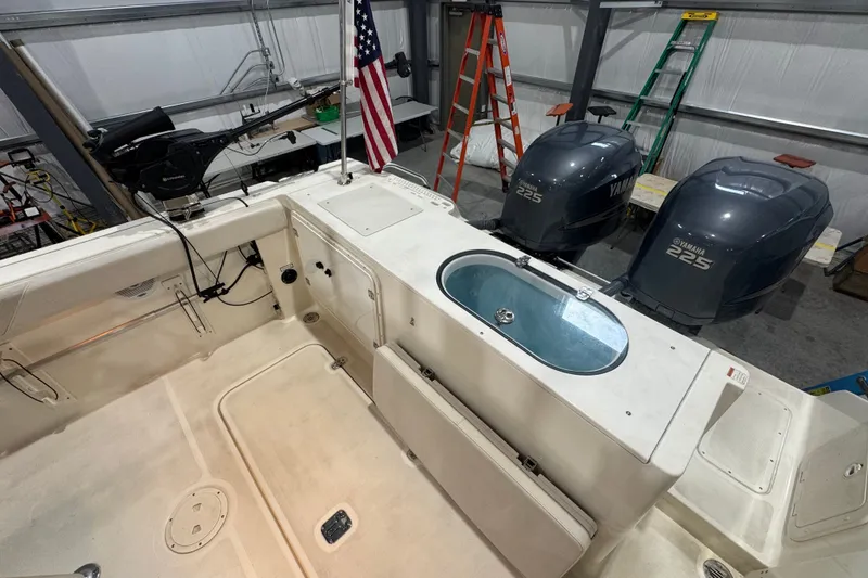 Slide: The Image of 2005 Pursuit 2670 Center Console boat interior with Yamaha 225 engines in a garage. - 28