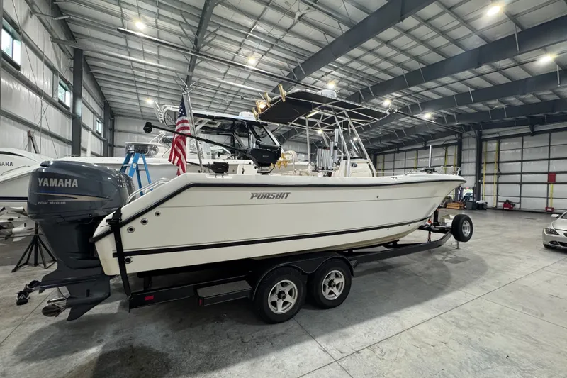 Slide: The Image of 2005 Pursuit 2670 Center Console boat in a warehouse, on a trailer with Yamaha engine. - 35