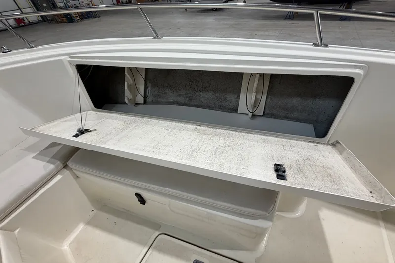 Slide: The Image of Open storage compartment on a 2005 Pursuit 2670 Center Console boat. - 16