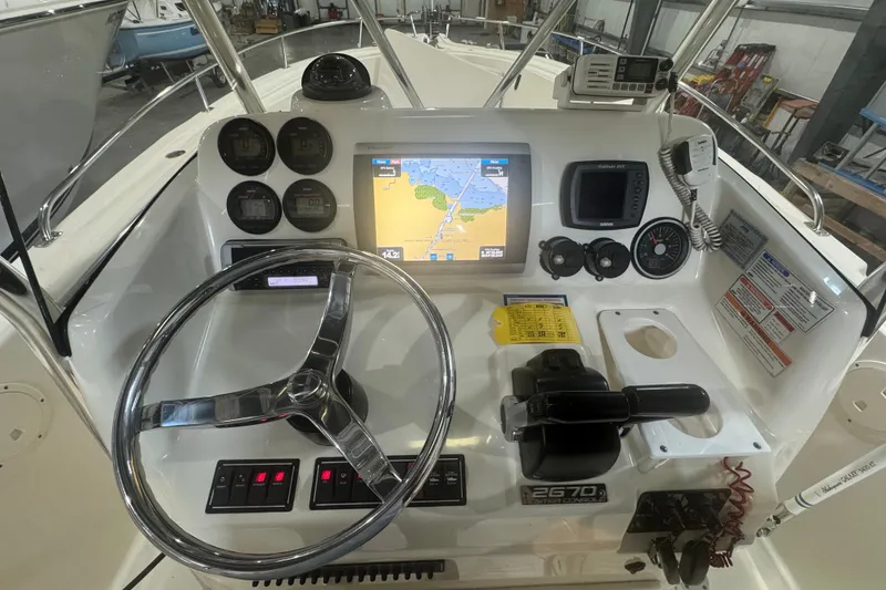 Slide: The Image of 2005 Pursuit 2670 Center Console boat dashboard with navigation and control instruments. - 26