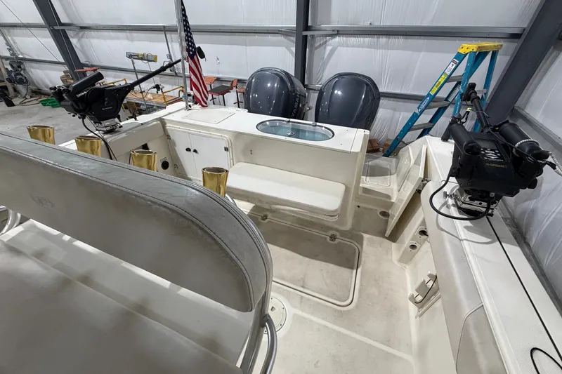 Slide: The Image of 2005 Pursuit 2670 Center Console boat interior with dual engines in a garage setting. - 25