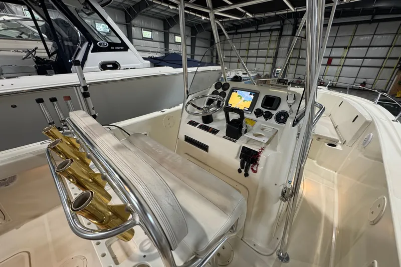 Slide: The Image of 2005 Pursuit 2670 Center Console boat interior with navigation equipment and rod holders. - 30