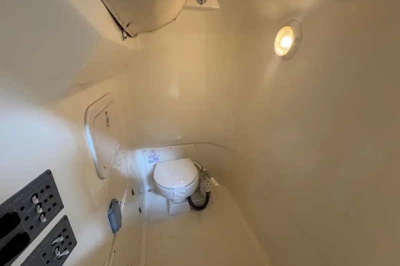 Slide: The Image of Interior of 2005 Pursuit 2670 Center Console boat with marine toilet and control panels. - 37