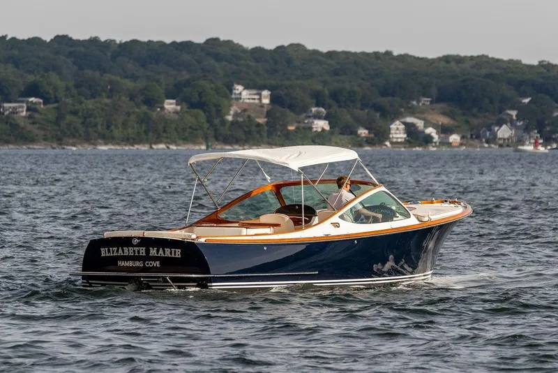 Slide: The Image of 2008 Hinckley Talaria 29R boat cruising on water near a scenic shoreline. - 32