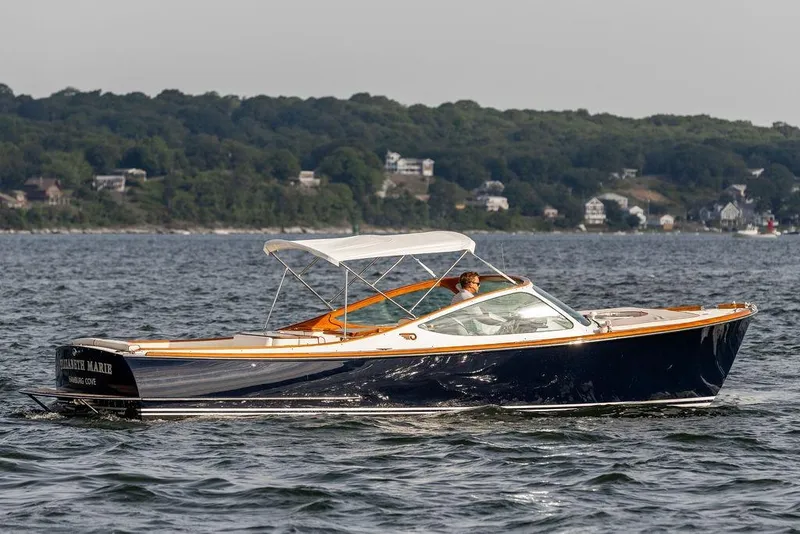 Slide: The Image of 2008 Hinckley Talaria 29R cruising on water with scenic shoreline background. - 6