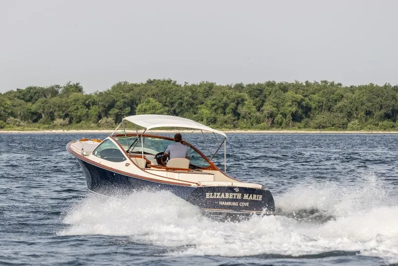 Slide: The Image of 2008 Hinckley Talaria 29R cruising on water near lush shoreline. - 42
