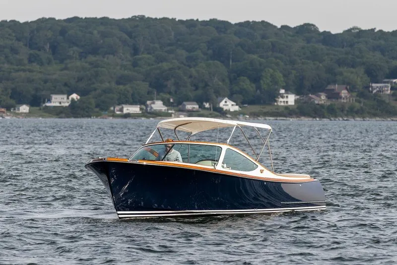 Slide: The Image of 2008 Hinckley Talaria 29R cruising on a scenic lake with forested shoreline. - 31