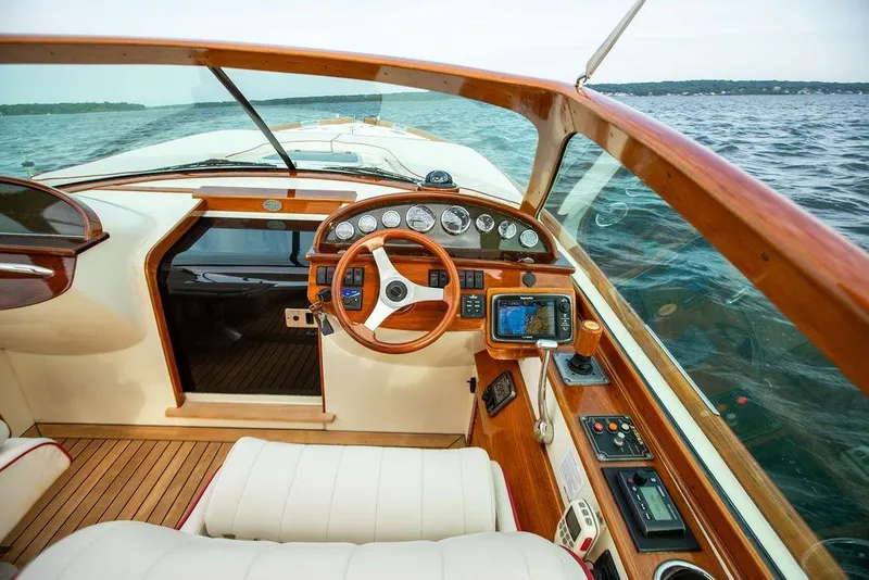 Slide: The Image of Interior of 2008 Hinckley Talaria 29R boat, featuring elegant wood finish and modern navigation controls. - 8