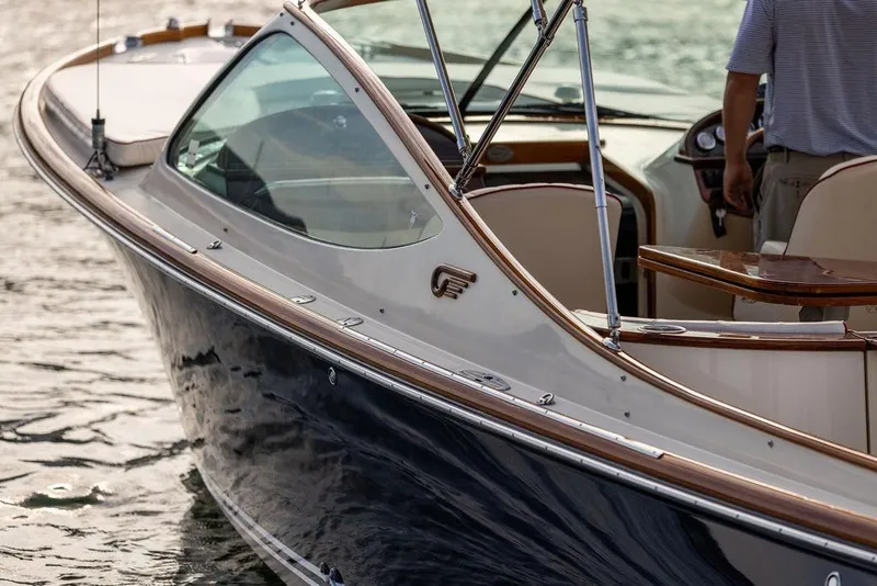 Slide: The Image of 2008 Hinckley Talaria 29R boat on water, featuring elegant design and wooden accents. - 26