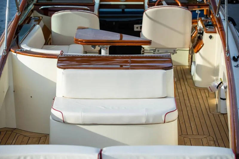 Slide: The Image of Hinckley Talaria 29R 2008 boat interior with elegant wood and white seating. - 19